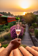Summer vacation on Mediterranean sea, drinking cold rose champagne, cava sparkling wine in glass in...