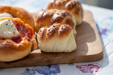 Fresh baked bread, pizza, focaccia or pizzetta with tomatoes, vegetables, sausage and cheese, street food in Palermo, Sicily, Italy, served outdoor for lunch
