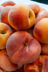 Fresh ripe sweet yellow and flat peaches Prunus persica or doughnut peach or Saturn peach