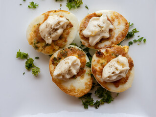 French high cuisine starter dish, pan fried chicken eggs with special filling and yellow sauce, vegetarian food in French restaurant