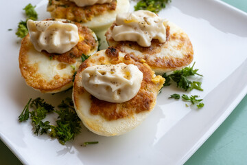 French high cuisine starter dish, pan fried chicken eggs with special filling and yellow sauce, vegetarian food in French restaurant