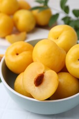 Ripe yellow cherry plums on white tiled table, closeup