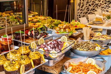 Delicious fresh cooked street food on daily food market in Palermo, Sicily, travel destination, food tourism Italy, variety of roasted, grilled fish, seafood, meat, vegetables served snacks, dish