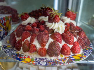 Sicilian desserts, sweets, cakes with ricotta cream, fruits, pistachio, on display in confectionery artisan shop