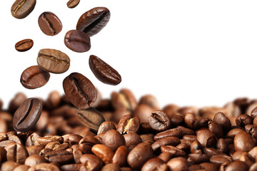 Roasted coffee beans falling onto heap against white background