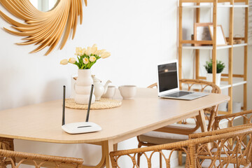 Modern wi-fi router on dining table in light room