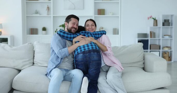 Adoption. Happy parents and their son having fun together at home