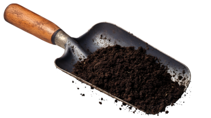 A garden trowel filled with dark brown soil against a plain black background in a studio shot