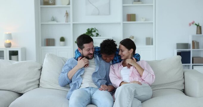 Adoption. Happy parents and their son having fun together at home - Powered by Adobe