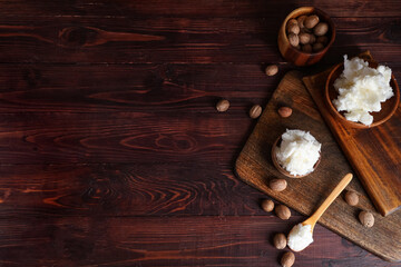 Composition with shea butter and nuts on dark wooden background