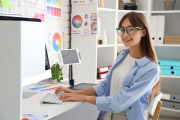 Female graphic designer working with computer at table in office