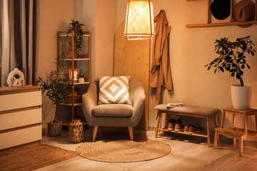 Interior of dark hallway with armchair, chest of drawers, bench and glowing lamps