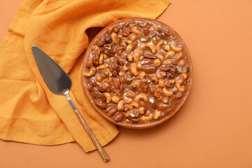 Sweet tart with different nuts and caramel on brown background