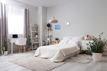Interior of light teenager's room with bed, shelf units and study table