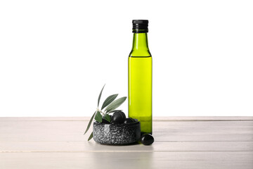Bottle of fresh olive oil on wooden table against white background