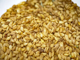 A full-frame photograph of golden roasted sesame seeds creating a detailed and textured background the image represents healthy ingredients used in cooking and baking