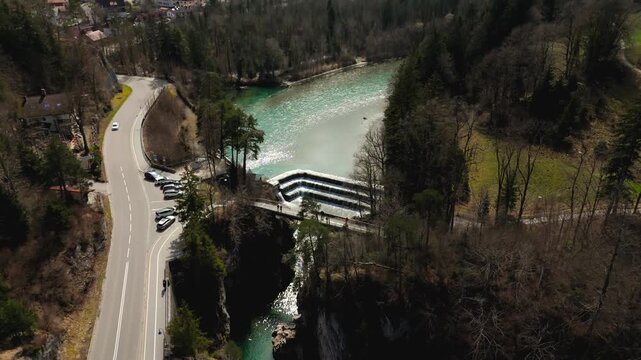 A breathtaking aerial view of Lechfall in Fussen, Germany. The turquoise waters cascade over the dam, surrounded by rugged cliffs and lush forests. A must-visit natural wonder in the Bavarian Alps