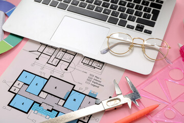 Architect's supplies with laptop and house plan on pink background, closeup