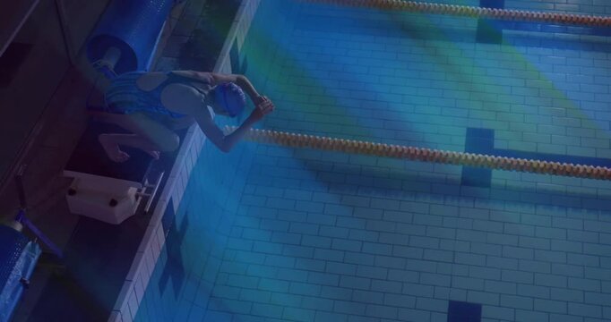 Female swimmer reacting to buzzer and diving from block for sports training and gliding underwater