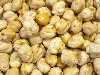 A full-frame macro shot of uncooked chickpeas filling the entire image the detailed texture of the...