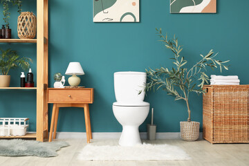 Interior of restroom with toilet bowl, table and shelf unit