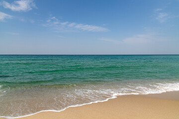 tranquil seascape with clouds in the sky and waves on the beach