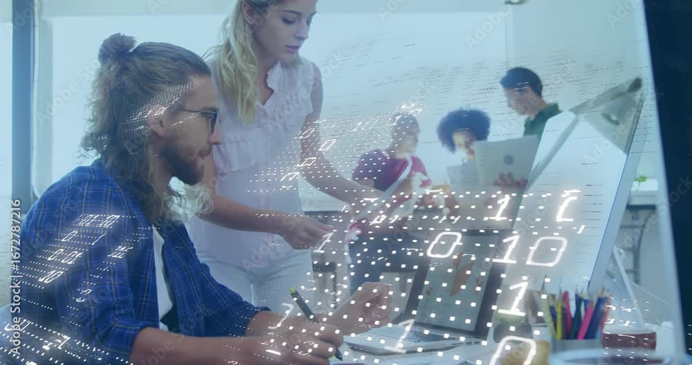Poster designer tapping tablet while woman leaning over showing sales charts and initiating binary overlay