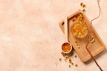 Wooden board with bowl and scoop with fish oil capsules on color background