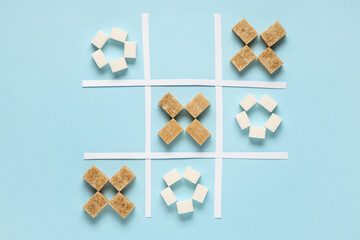 Tic tac toe game with sugar cubes on blue background