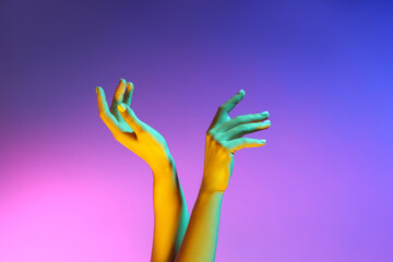 Toned female hands on color background