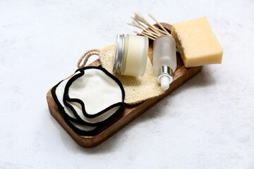 Cotton pads, cosmetics and bath supplies on light background