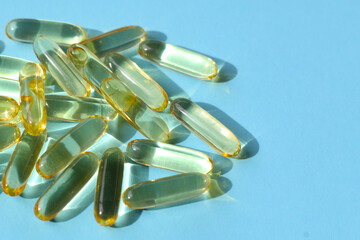 Transparent softgel capsules of Vitamin E supplements, known for supporting skin health,...