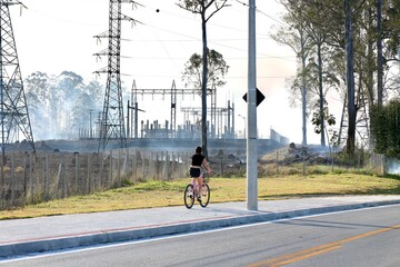 Linha de transmissão elétrica no meio da fumaça após incêndio em área de vegetação....