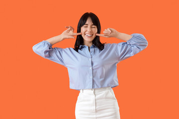 Young woman with beautiful smile on orange background