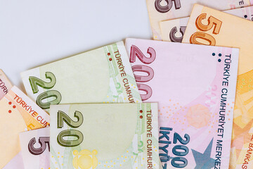 Different Turkish banknotes including 5, 20, 200 lira displayed together on neutral surface.