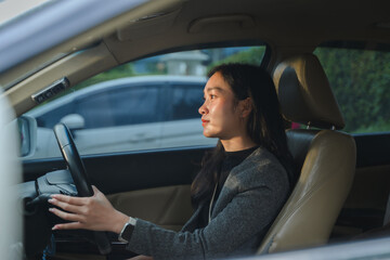 Businesswoman driving car during sunset wearing smartwatch