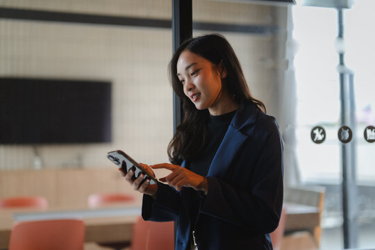 Young businesswoman using mobile phone in modern office space
