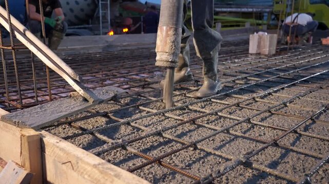 Concrete being poured onto rebar foundation at construction site