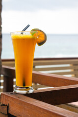 Fresh orange juice with orange slices, summer drink on the beach