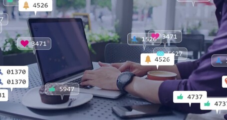 Freelancer typing on laptop at cafe while generating social media icons clustering then dispersing - Powered by Adobe