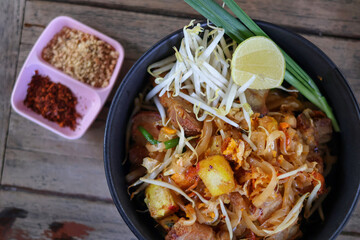 High angle view of Pad Thai with Crispy Pork Belly (Pad Thai Moo Krob) in plat. Popular Thai food in Thailand
