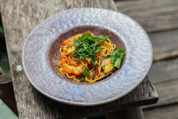 Side view of seafood basil spaghetti. It has a spicy Thai flavor.