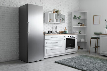 Interior of kitchen with modern fridge, counter and shelves