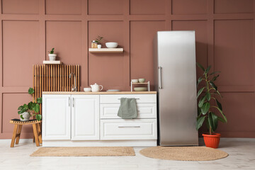Interior of stylish kitchen with modern fridge, counters and shelves