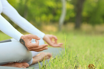 Young woman meditating in park, closeup