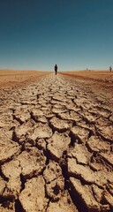 Solitary figure trekking across a cracked, arid landscape under a vast, clear sky