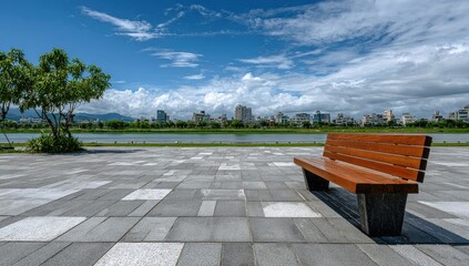 Tranquil park bench overlooking a cityscape and lake under a bright sky