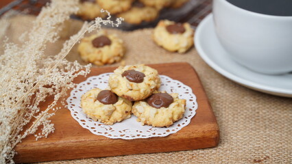 Homemade chocolate thumbprint cookies with peanut sprinkles and with hot black coffee, isolated on a clean white background. 