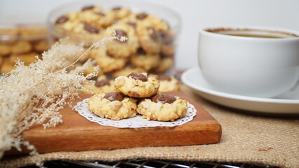 Homemade chocolate thumbprint cookies with peanut sprinkles and with hot black coffee, isolated on a clean white background. 