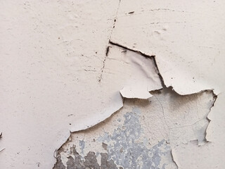 background of peeling wall paint, close up of wall texture with peeling wall paint due to water and...